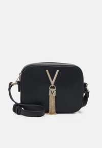 Borsa a tracolla in faux pelle nera con hardware dorato, caratterizzata da un logo a forma di 'V' e un dettaglio con nappina a catena. Forma rettangolare compatta con chiusura a zip.