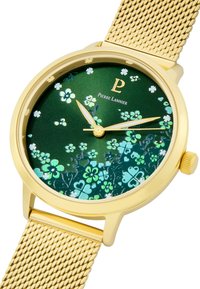 Reloj con correa de malla dorada y esfera verde con un patrón floral y detalles dorados, manos luminosas. Logotipo de la marca mostrado en la esfera.
