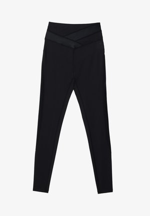 Black leggings with a wide, crossed waistband and contrasting textured panels. Smooth fabric, fitted shape, and flat seams for comfort.