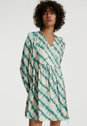 Langarmige jurk van crèmekleurige stof met een teal tie-dye patroon, v-hals, gathered taille en geplooide accenten op de mouwen.