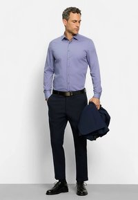 Light purple button-up shirt, dark blue trousers, black shoes, and a navy blazer draped over the arm. Smooth fabric with a tailored fit.