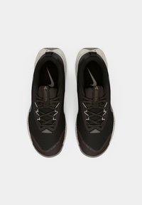 Zwarte sport sneakers met een bovenkant van mesh, reflecterende accenten, gestructureerde rubberen zolen en grijze details. Voorzien van veters en een logo.
