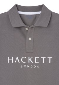Polo grigio realizzato in tessuto testurizzato, dotato di colletto classico, due bottoni e logo bianco: "HACKETT LONDON" stampato sul davanti.