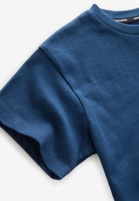 Niebieski bawełniany t-shirt z okrągłym dekoltem i krótkimi rękawami. Tkanina jest gładka, z widocznymi przeszyciami przy krawędzi dołu i rękawów.