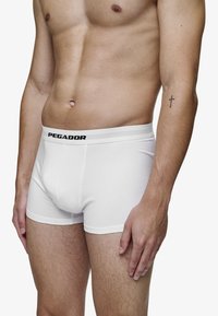 Hvite bomullsboxershorts med svart "PEGADOR"-logo på midjebåndet. Funksjoner inkluderer en tettsittende passform, en glatt tekstur og et klassisk design.