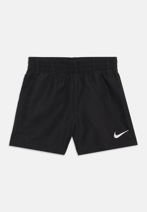 Čierne atletické šortky s elastickým pásom a bielym logom Nike Swoosh na spodnej pravej nohe, položené na svetlom pozadí.