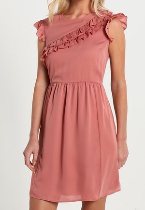 Růžové šaty bez rukávů s volánkovými krátkými rukávy a diagonálním volánkem přes hrudník, přiléhavým pasem a sukní délky ke kolenům.