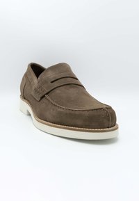 Mocassins en suède marron avec un design de mocassin, présentant un bout cousu, deux sangles horizontales et une semelle en caoutchouc blanc contrastant.