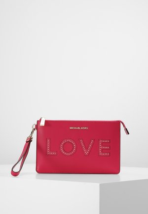 Czerwony portfelik na nadgarstek Michael Kors z złotym zamkiem błyskawicznym, paskiem na nadgarstek i ozdobnym napisem "LOVE" z przodu.