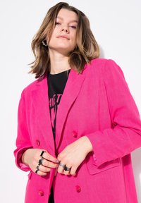 Ljust rosa dubbelknäppt blazer med en skräddarsydd passform, som har spetsiga slag, överdimensionerade knappar och en mjuk textur.