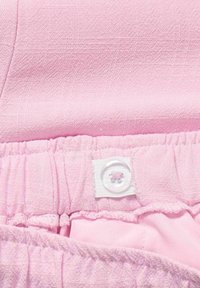 Light pink fabric featuring a textured finish, with a gathered waistband and white button detail. Smooth interior lining visible.