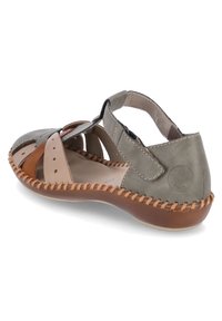 Sandale en cuir gris avec un design ouvert, dotée d'accents beiges, de détails cousus et d'une semelle en caoutchouc marron. Sangle ajustable pour un bon maintien.