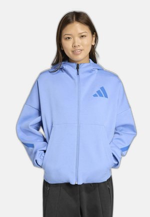 Hellblauer Kapuzenpullover mit Reißverschluss aus weichem Stoff, mit Kapuze, Vorderseitentaschen und blauen Akzentstreifen an den Ärmeln.