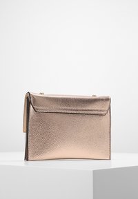 Rosa guld texturerad handväska med lockstängning och subtila sömnadsdetaljer. Har en slank, rektangulär design och minimala hårdvaruaccentuationer.
