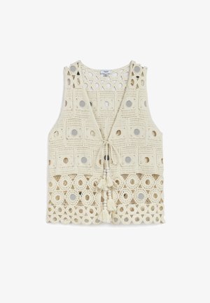 Crochet vest in cream with circular mirror accents. Features a deep V-neck and decorative tassels at the hem and closure. Openwork design.
