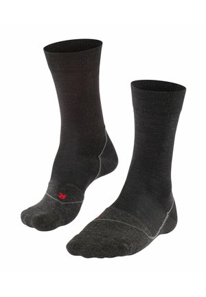 Schwarze knöchellange Socken mit gerippter Textur, kontrastierenden grauen Akzenten an Zehen und Ferse sowie einem kleinen roten Logo in der Nähe des Knöchels.