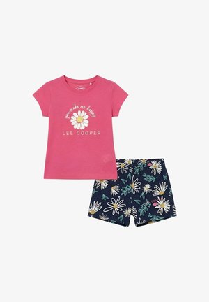 Chemise rose à manches courtes avec un motif de marguerite et le texte "tu me rends heureux", assortie à un short bleu marine avec des motifs de marguerites blanches et jaunes.
