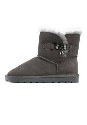 Bottines en suede gris avec une bordure en fourrure douce, un nœud décoratif avec des accents en métal, et une semelle en caoutchouc texturée pour une bonne adhérence.