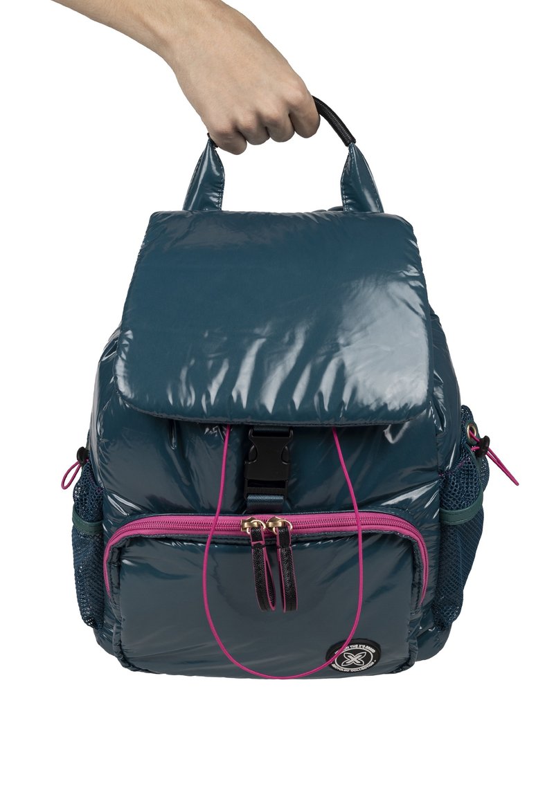 Mochila de color teal brillante con dos bolsillos con cremallera, un asa en la parte superior, bolsillos laterales de malla y acentos rosas en el cierre y los detalles.