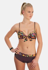 Ensemble de bikini deux pièces comprenant un haut marron à motifs avec un nœud et un bas marron assorti avec une taille décorative. Texture lisse.