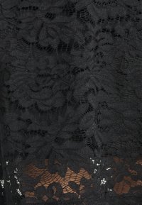 Černá krajka s květinovými vzory, která se vyznačuje různými texturami a otevřenými tkaninami, vytvářejícími vrstvený vzhled.