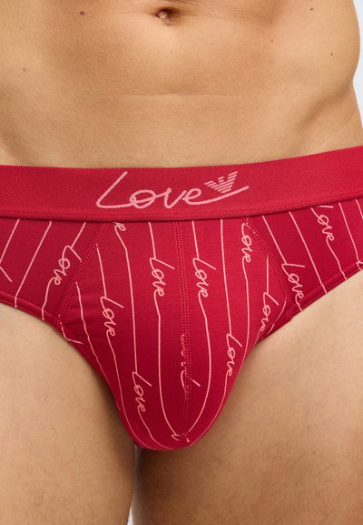 Piros alsónadrág rózsaszín csíkokkal és ismétlődő "love" felirattal. A rugalmas derékrész írott betűs "Love" feliratot tartalmaz. Puha, rugalmas anyag.