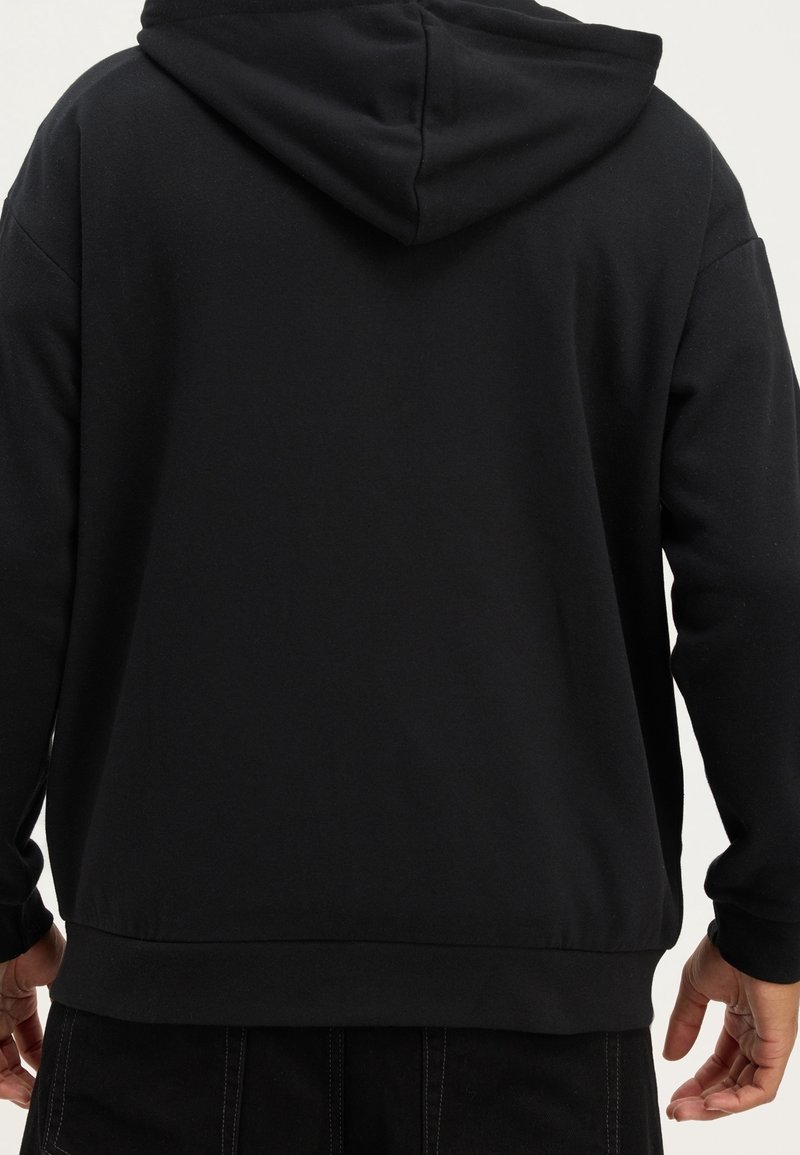 Svart sweatshirt med huva, tillverkad av mjukt material, med normal passform och ribbade muddar och nederdel, med minimal detaljering på baksidan.