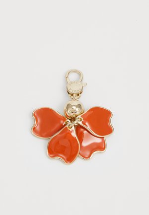 Red enamel floral charm with four petal-like sections, linked by a gold-tone metal chain and featuring a round gold pendant labeled "Furla."
