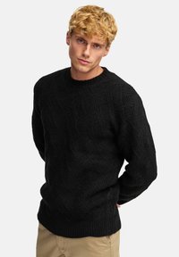 Schwarzer Strickpullover mit einem strukturierten Zickzackmuster, rundem Ausschnitt und gerippten Bündchen. Normale Passform mit einem klassischen, gemütlichen Aussehen.