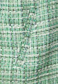 Tela tejida en verde, blanco y azul claro, con un patrón texturizado que presenta hilos finos y un detallado intrincado.