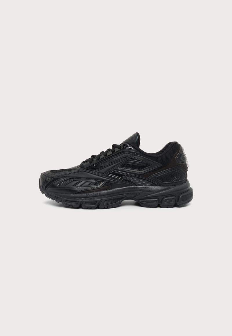 Baskets de sport noires avec des panneaux texturés détaillés, une semelle épaisse et un laçage à l'avant, vues de profil sur un fond uni.