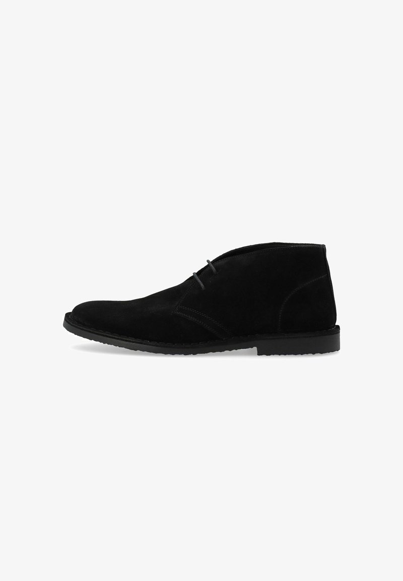 Black suede ankle boots featuring a rounded toe, minimal stitching detail, and a flat rubber sole. The design is simple and classic.