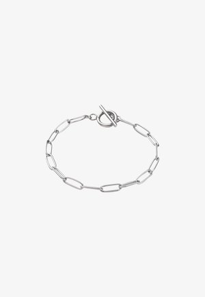 Srebrna bransoletka na ogniwach o wydłużonychlinkach i z zapięciem typu toggle. Gładka, wypolerowana powierzchnia metalu; charakteryzuje się minimalistycznym wzornictwem.