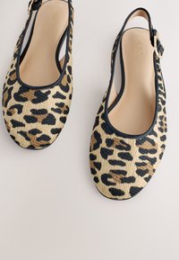 Leopardenmuster Slingback Ballerinas mit abgerundeter Spitze, schwarzer Paspelierung und goldfarbener Schnalle am Knöchelriemen.