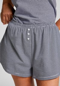Gestreepte lounge shorts in grijs en wit katoen. Elastische tailleband met een drieknoopsluiting. Zachte textuur en een relaxte pasvorm.