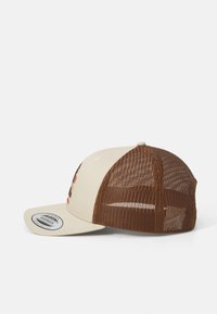 Beige honkbalpet met een bruine gaasachterkant, met een geborduurd design aan de voorkant. Platte rand en verstelbare snapback sluiting.