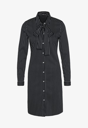 Sort-hvid stribet skjortekjole med lange ærmer, spids krave, knaplukning og bundet sløjfedetalje ved halsen.