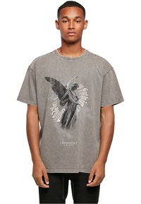 Grå, oversized t-shirt lavet af bomuld, med et graphic af en engel statue og tekst på kyrillisk nederst. Slidt halsudskæring og kant.