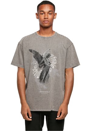 Camiseta gris de gran tamaño hecha de algodón, con una gráfica de una estatua de ángel y texto en cirílico en la parte inferior. Cuello y dobladillo desgastados.
