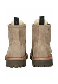 Botas de tobillo de ante marrón con un acabado texturizado, puntera redondeada y suela de goma contrastante; cuenta con un forro interior suave y una lengüeta.
