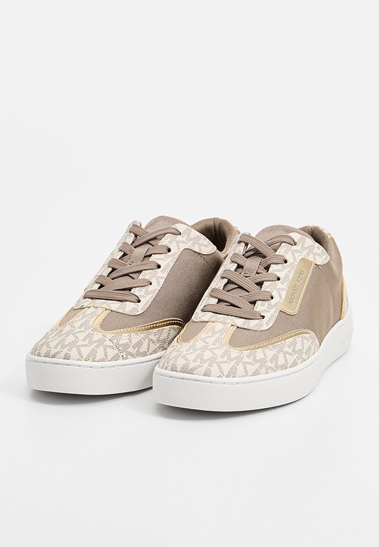 Baskets beiges avec un sommet textured à motif, des accents bruns et une semelle en caoutchouc blanche. Design à lacets avec un détail en métal.