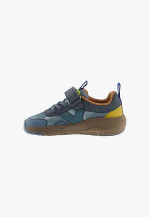 Blauwe kindersneaker met bruine zool, gele hielpatch, blauwe lusstabs en een klittenbandsluiting over de veters op een witte achtergrond.