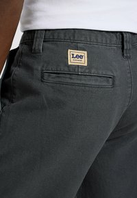 Ciemnoszare spodnie robocze Lee z teksturowanej tkaniny, z standardową tylną kieszenią i metką marki powyżej kieszeni.