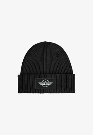 Black knit beanie with ribbed texture and a folded cuff. Features a rectangular patch with a star and wing design in white.
