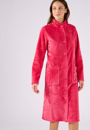 Cappotto lungo di pile rosa con colletto alto, bottoni frontali e due tasche applicate. Tessuto testurizzato con una finitura morbida e un design leggero.
