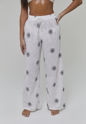 Hvide hør bukser med vide ben har sort solbroderi, elastik i taljen og sidelommer for øget funktionalitet.
