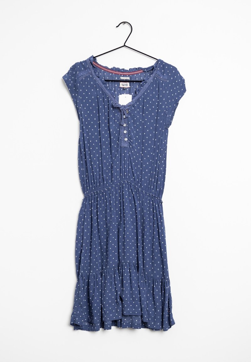 Sininen, lyhythihainen mekko, joka on valmistettu kevyestä kankaasta. Mekossa on valkoisia pilkkuja, nauhakiinnitys edessä, napit ja röyhelöhelma.