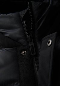 Zwarte geïsoleerde jackdetail met een textuurstof, opvallende rits en zilveren drukknoop. Glad oppervlak en slank ontwerp.