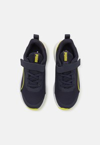 Scarpe da ginnastica atletiche in rete blu navy con cinturino in Velcro e lacci, presentano dettagli gialli e una suola in gomma bianca per trazione e supporto.