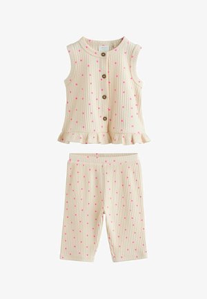 Top crem fără mâneci, cu dungi, cu buline roz, nasturi în față, tiv cu volane și pantaloni scurți asortați, cu dungi și buline roz.